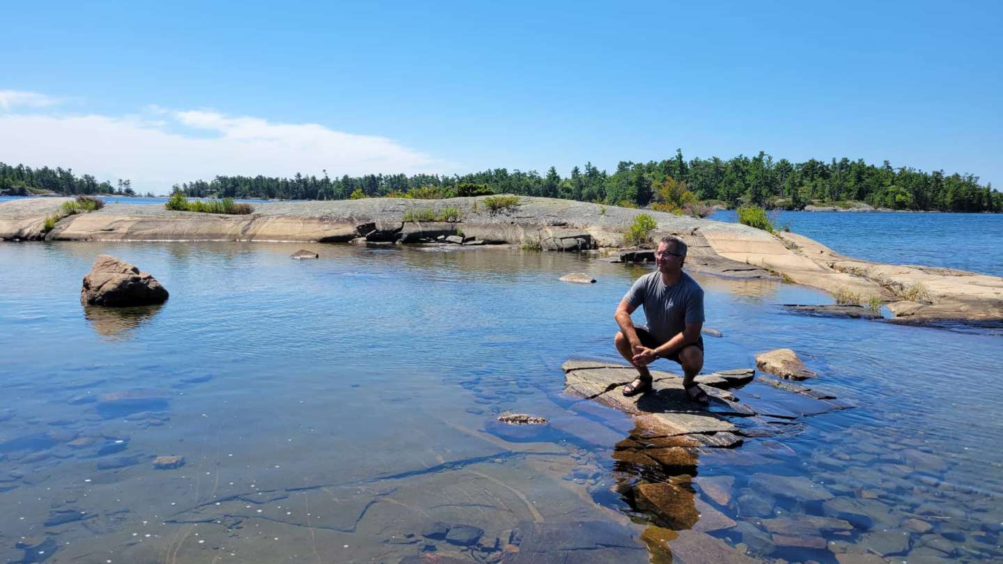 Tom Homer in nature looking off into the distance.
